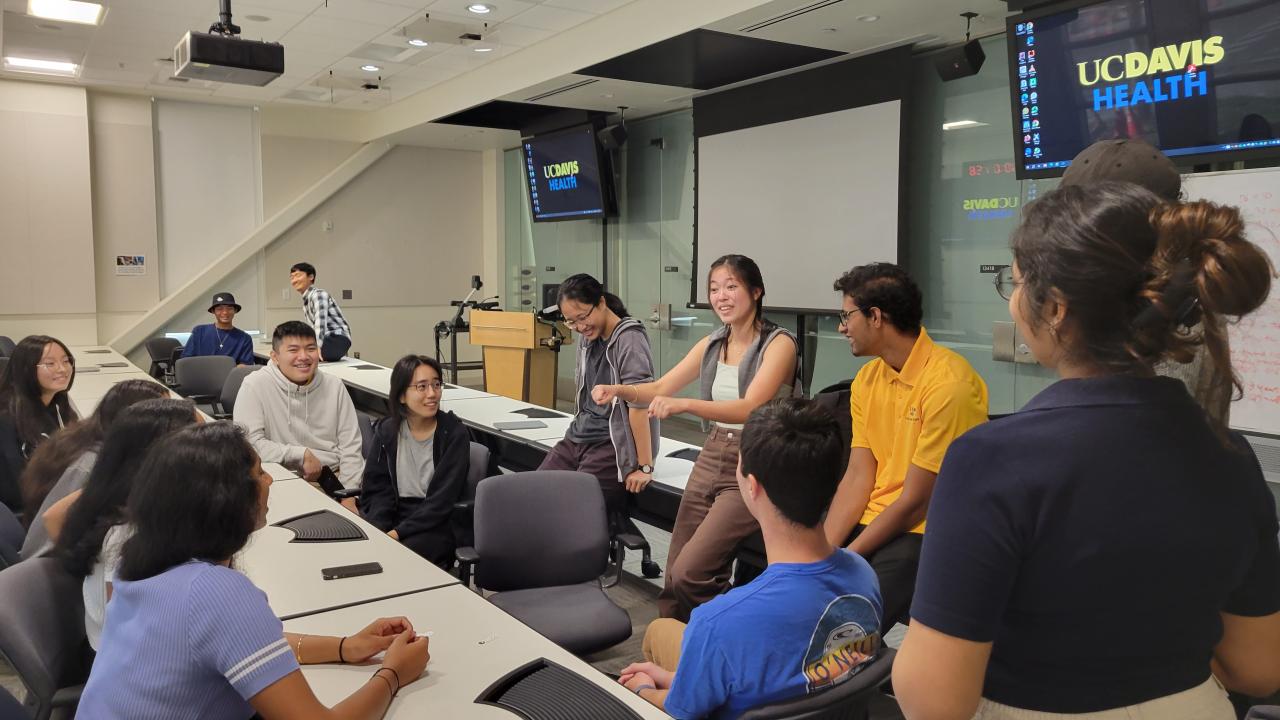 Students in a classroom with UC Davis health logo on tv monitors