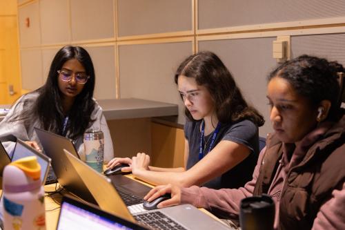 Three female students working on laptops
