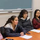Four students gather around a table in conversation